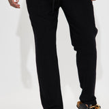 Pantalones negros de lino con textura sólida y cintura elástica lateral con abertura en los costados.