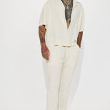 Pantalones de lino sólido con textura de cintura elástica y abertura lateral - Crema