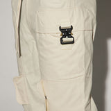 La perfección es perfeccionada con los pantalones de carga rectos y utilitarios en color blanco.