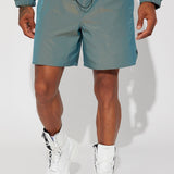 Shorts de nylon iridiscente con estampado de tormenta y color verde.